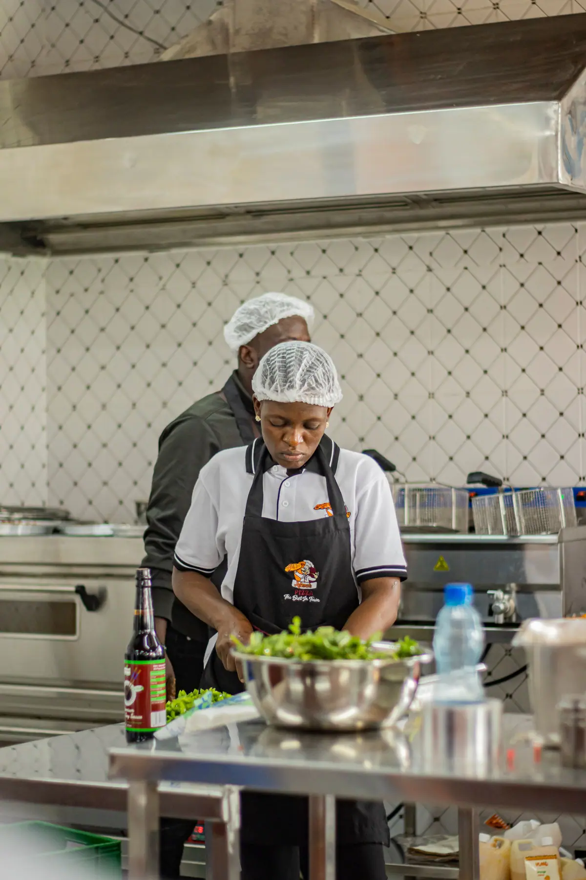 A chef in a white uniform preparing food in a kitchen.